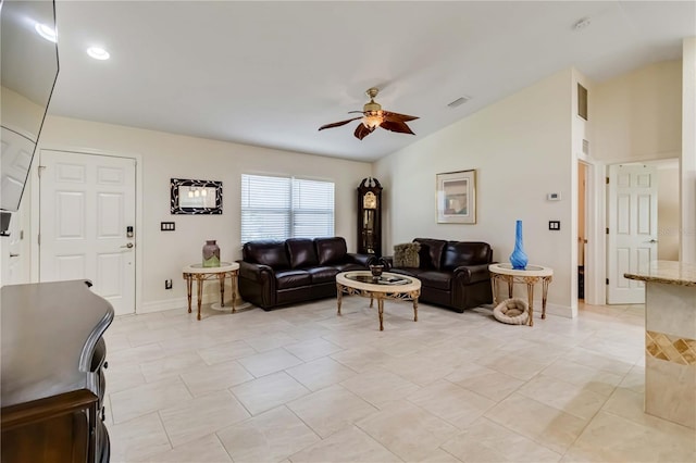 living area with vaulted ceiling, ceiling fan, baseboards, and light tile patterned floors