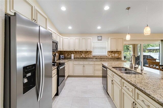 kitchen with appliances with stainless steel finishes, a sink, decorative backsplash, light stone countertops, and recessed lighting
