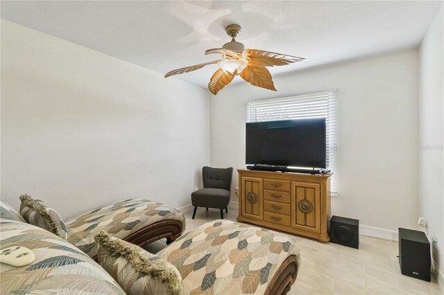 living area featuring ceiling fan and baseboards