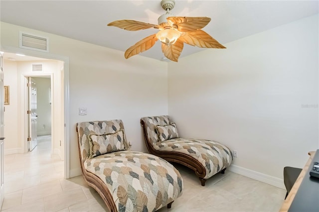 living area featuring a ceiling fan, light tile patterned floors, and baseboards