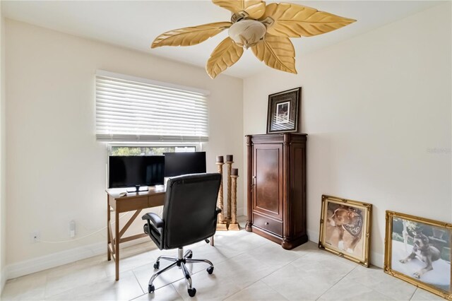 office space with a ceiling fan, baseboards, and light tile patterned floors