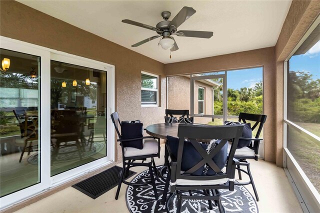 sunroom / solarium with a ceiling fan and outdoor dining area