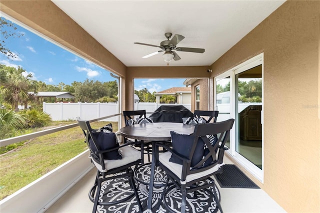 sunroom featuring a ceiling fan and outdoor dining space