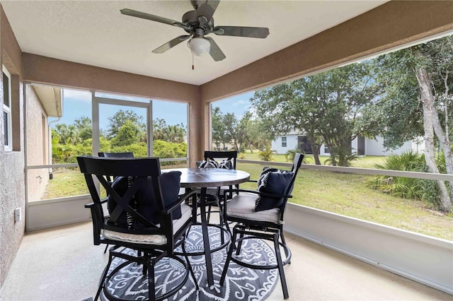 sunroom with a ceiling fan, healthy amount of natural light, and outdoor dining space