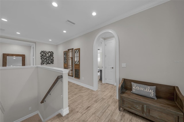 hallway with crown molding, arched walkways, recessed lighting, baseboards, and an upstairs landing