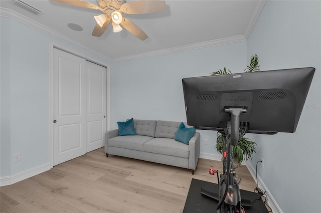interior space featuring visible vents, crown molding, wood finished floors, baseboards, and a ceiling fan