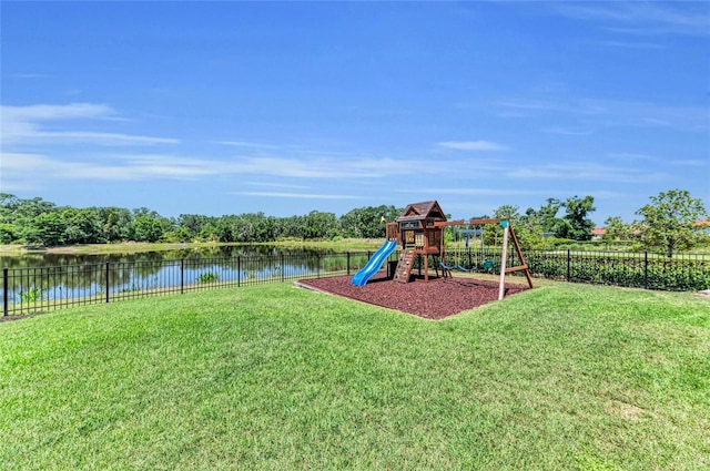 view of jungle gym featuring a yard, a water view, and a fenced backyard