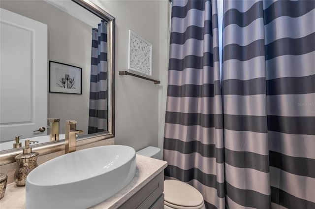 bathroom with toilet, curtained shower, and vanity