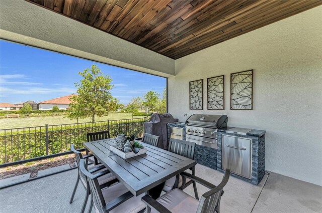 view of patio with outdoor dining space, fence, grilling area, and area for grilling