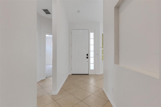 entryway with light tile patterned floors and baseboards