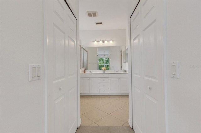 hall with light tile patterned floors and a sink