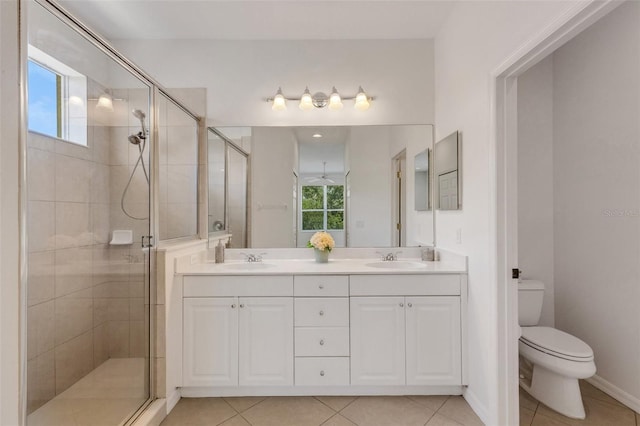 bathroom featuring a shower stall, toilet, double vanity, and tile patterned floors