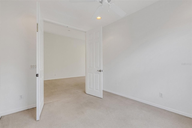 spare room featuring light colored carpet, a ceiling fan, recessed lighting, and baseboards