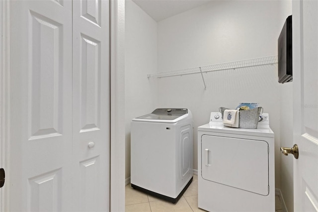 laundry area featuring independent washer and dryer and light tile patterned flooring