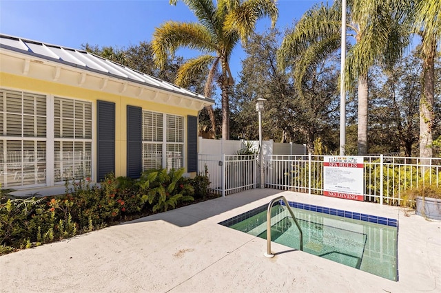 view of pool with a hot tub and fence
