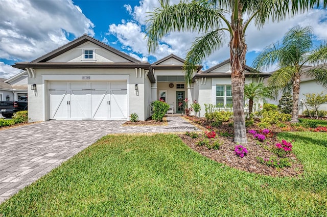 749 Tailwind Pl, Sarasota, FL 34240 - view of front of property featuring decorative driveway, an attached garage, a front lawn, and stucco siding