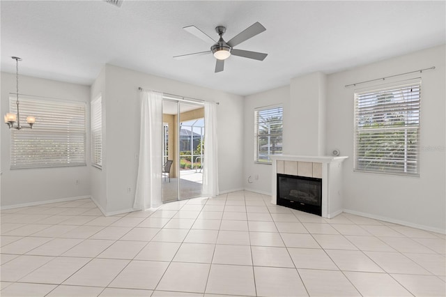 12014 Beeflower Dr, Lakewood Ranch, FL 34202 - unfurnished living room with a tiled fireplace, baseboards, and ceiling fan with notable chandelier