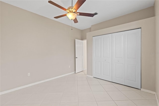 12014 Beeflower Dr, Lakewood Ranch, FL 34202 - unfurnished bedroom with light tile patterned floors, baseboards, a ceiling fan, and a closet