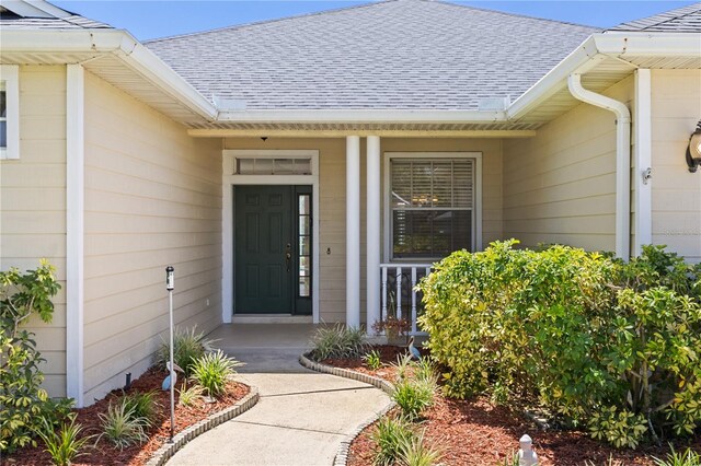 12014 Beeflower Dr, Lakewood Ranch, FL 34202 - entrance to property with a shingled roof and covered porch