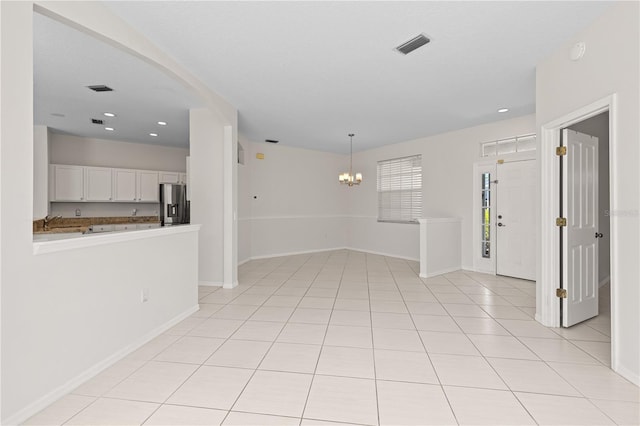 12014 Beeflower Dr, Lakewood Ranch, FL 34202 - empty room with visible vents, a sink, baseboards, an inviting chandelier, and light tile patterned flooring