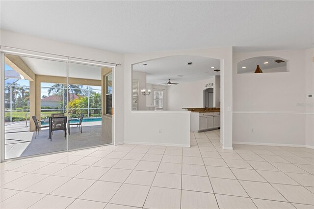 12014 Beeflower Dr, Lakewood Ranch, FL 34202 - unfurnished living room featuring a ceiling fan, baseboards, and light tile patterned flooring