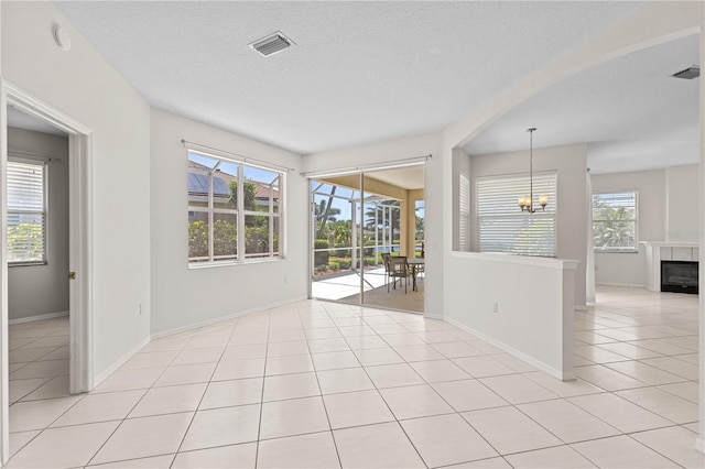 12014 Beeflower Dr, Lakewood Ranch, FL 34202 - unfurnished room featuring visible vents, baseboards, a textured ceiling, a chandelier, and light tile patterned floors
