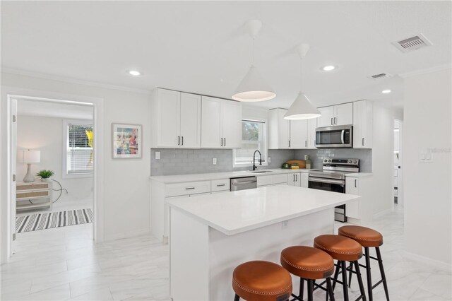 578-580 Companion Way, Longboat Key, FL 34228 - kitchen featuring tasteful backsplash, a breakfast bar, appliances with stainless steel finishes, a sink, and visible vents