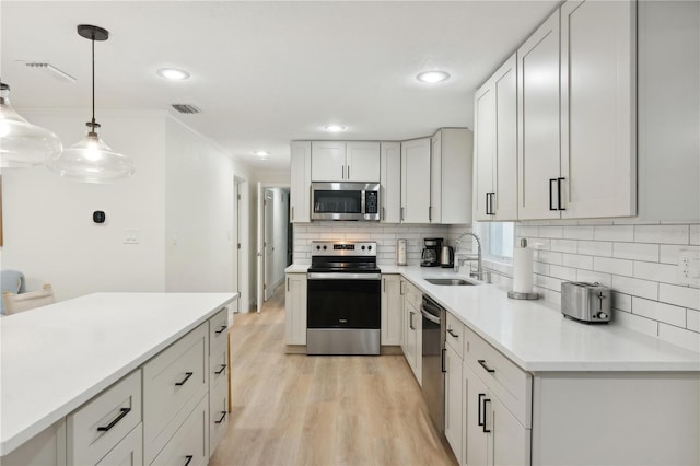 578-580 Companion Way, Longboat Key, FL 34228 - kitchen with light wood-style flooring, decorative backsplash, stainless steel appliances, a sink, and visible vents