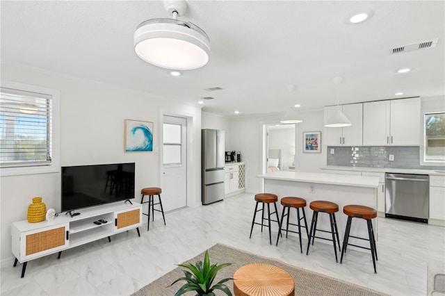 578-580 Companion Way, Longboat Key, FL 34228 - kitchen featuring white cabinetry, a breakfast bar, appliances with stainless steel finishes, and light countertops