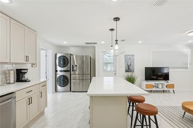 578-580 Companion Way, Longboat Key, FL 34228 - kitchen featuring a kitchen breakfast bar, appliances with stainless steel finishes, stacked washer and clothes dryer, visible vents, and a kitchen island