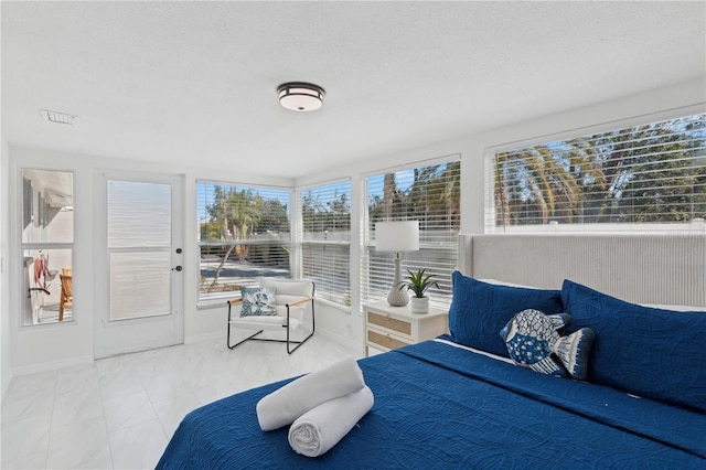 578-580 Companion Way, Longboat Key, FL 34228 - bedroom with a textured ceiling, baseboards, and multiple windows