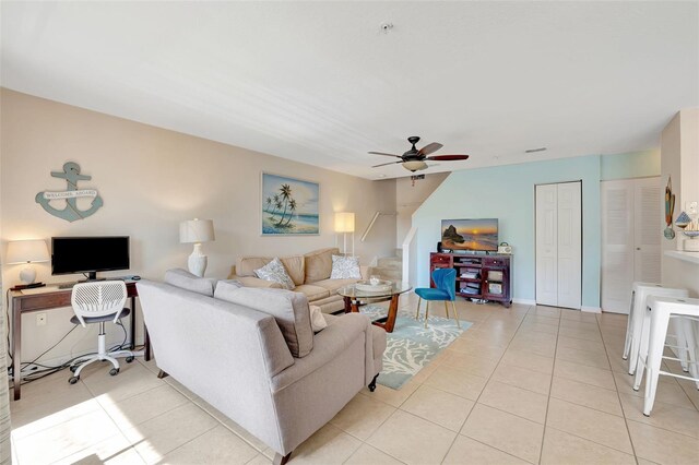 living area with a ceiling fan and light tile patterned flooring