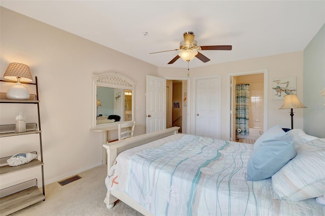 bedroom featuring ensuite bathroom, visible vents, baseboards, ceiling fan, and light colored carpet