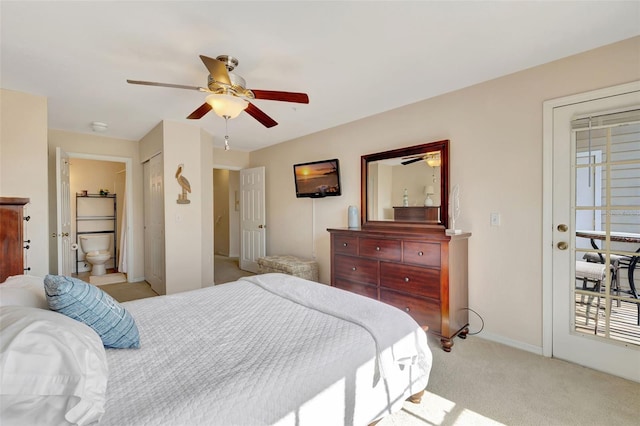 bedroom featuring baseboards, ensuite bathroom, a ceiling fan, and light colored carpet