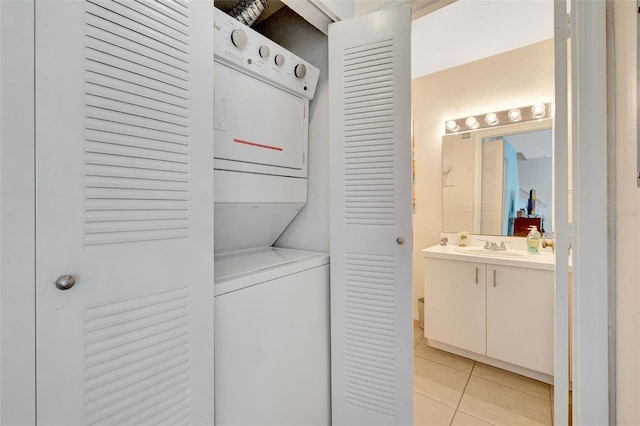 washroom featuring a sink, stacked washing maching and dryer, laundry area, and light tile patterned floors