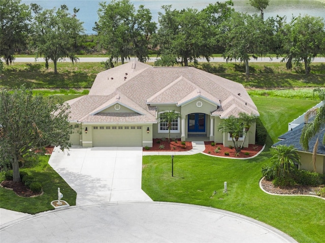 9106 Yarberry St, Sarasota, FL 34240 - mediterranean / spanish-style home featuring roof with shingles, an attached garage, driveway, stucco siding, and a front yard