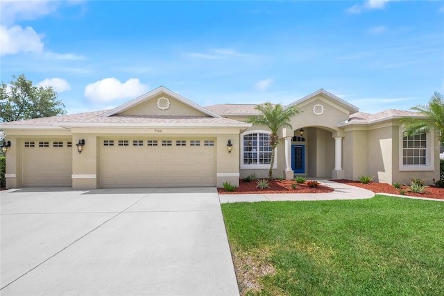 9106 Yarberry St, Sarasota, FL 34240 - view of front facade with concrete driveway, a garage, stucco siding, and a front yard