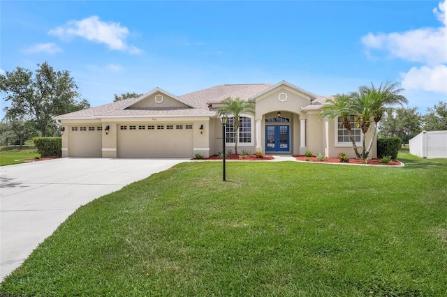 9106 Yarberry St, Sarasota, FL 34240 - view of front of property featuring an attached garage, french doors, stucco siding, concrete driveway, and a front lawn