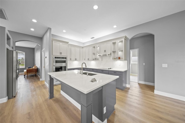 9106 Yarberry St, Sarasota, FL 34240 - kitchen with a sink, arched walkways, light countertops, gray cabinetry, and appliances with stainless steel finishes