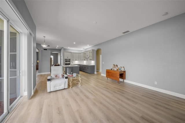 9106 Yarberry St, Sarasota, FL 34240 - living area featuring recessed lighting, baseboards, visible vents, arched walkways, and light wood-style floors