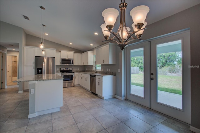 25 Sabot Ct, Placida, FL 33946 - kitchen featuring light stone countertops, a sink, vaulted ceiling, appliances with stainless steel finishes, and french doors