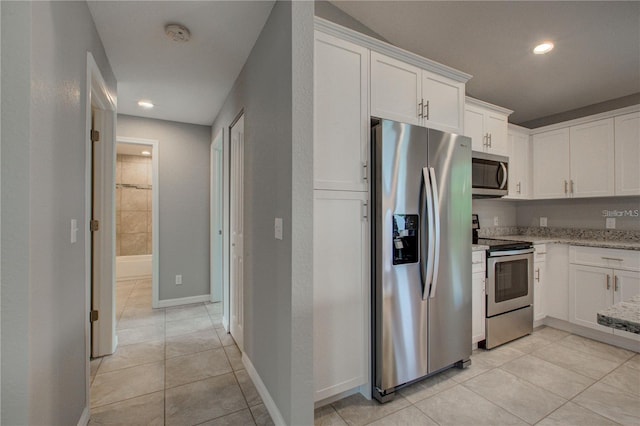 25 Sabot Ct, Placida, FL 33946 - kitchen with recessed lighting, light stone counters, light tile patterned floors, appliances with stainless steel finishes, and white cabinets
