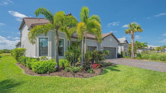 7889 Mainsail Ln, Sarasota, FL 34240 - view of front of home with stucco siding, a front lawn, an attached garage, a tile roof, and driveway