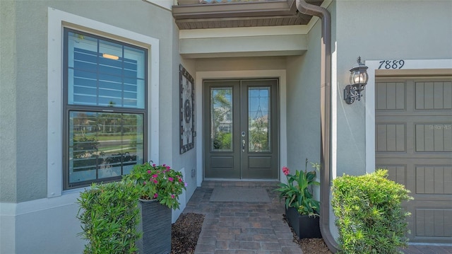 7889 Mainsail Ln, Sarasota, FL 34240 - view of exterior entry featuring french doors and stucco siding