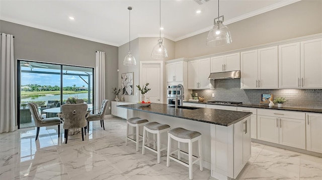 7889 Mainsail Ln, Sarasota, FL 34240 - kitchen with light marble finish flooring, appliances with stainless steel finishes, under cabinet range hood, crown molding, and white cabinets