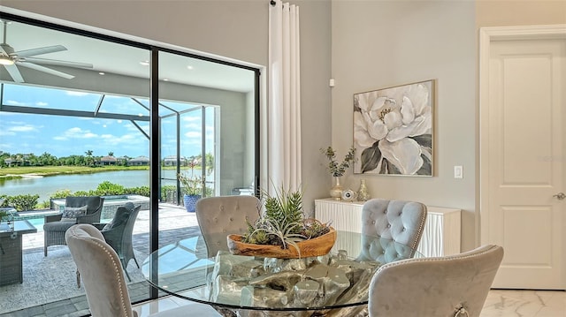7889 Mainsail Ln, Sarasota, FL 34240 - dining area featuring a sunroom, a ceiling fan, healthy amount of natural light, and a water view