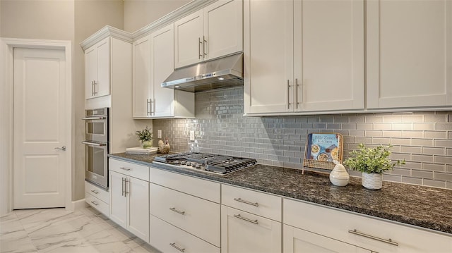 7889 Mainsail Ln, Sarasota, FL 34240 - kitchen featuring under cabinet range hood, stainless steel gas cooktop, dark stone countertops, light marble finish floors, and white cabinets