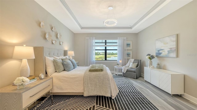 7889 Mainsail Ln, Sarasota, FL 34240 - bedroom with light wood-style floors, baseboards, a tray ceiling, and a chandelier