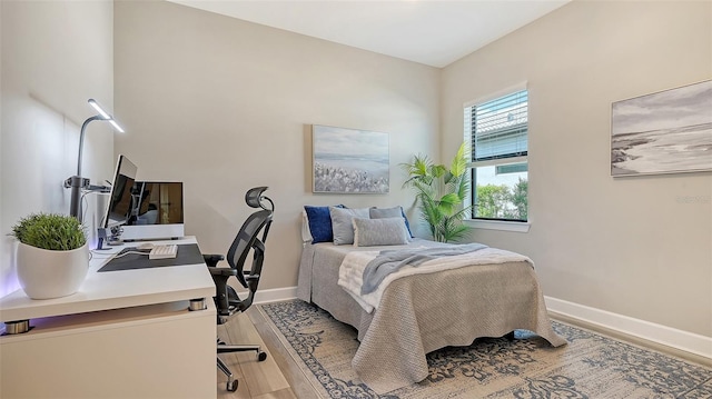 7889 Mainsail Ln, Sarasota, FL 34240 - bedroom with light wood finished floors, baseboards, and an office area