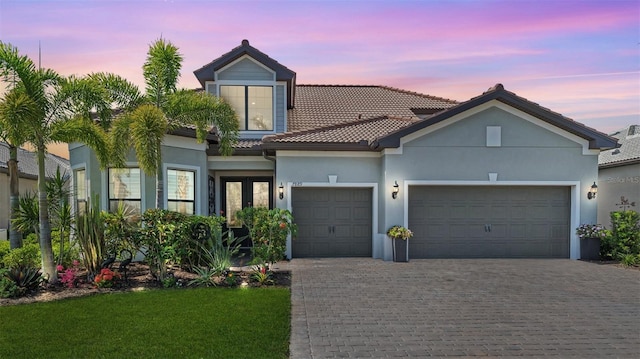 7889 Mainsail Ln, Sarasota, FL 34240 - mediterranean / spanish-style home with an attached garage, a tiled roof, driveway, and stucco siding